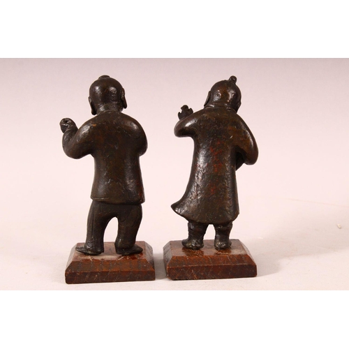 184 - A PAIR OF SMALL CHINESE CAST BRONZE FIGURES OF YOUNG BOYS, holding items in their hand, showing trac... 