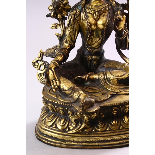 188 - A TIBETAN GILT BRONZE FIGURE OF A SEATED FEMALE DIETY, on lotus pad, 24cm high.