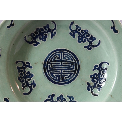 190 - A CHINESE CELEDON GROUND DISH, decorated with stylised bats, 27cm diameter.