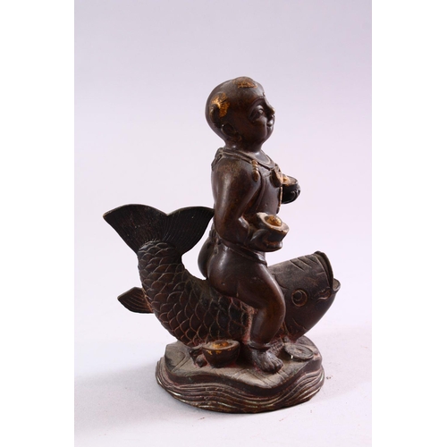 191 - A SMALL CHINESE BRONZE FIGURE OF A BOY SEATED UPON A CARP, 15cm high.