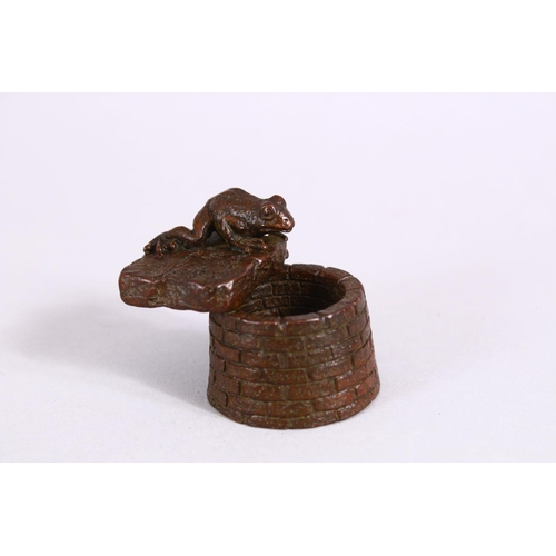 20 - A JAPANESE BRONZE FIGURE OF A TOAD OVER A WELL, with carved calligraphy to the toad base, the unders... 