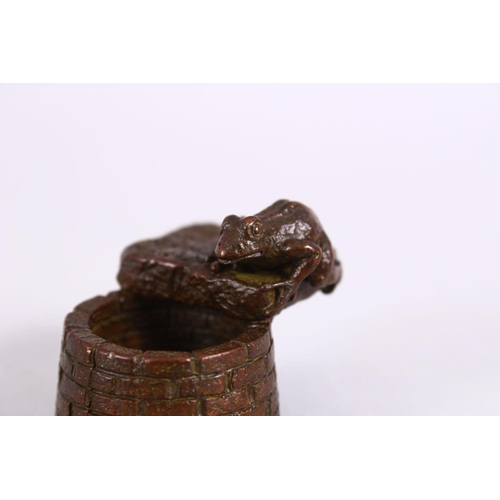 20 - A JAPANESE BRONZE FIGURE OF A TOAD OVER A WELL, with carved calligraphy to the toad base, the unders... 