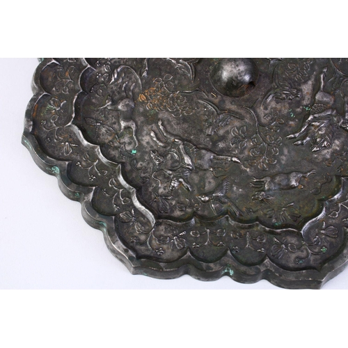 221 - A LARGE 18TH CENTURY CHINESE CAST BRONZE MIRROR, the decoration depicting a hunting scene, 24cm diam... 