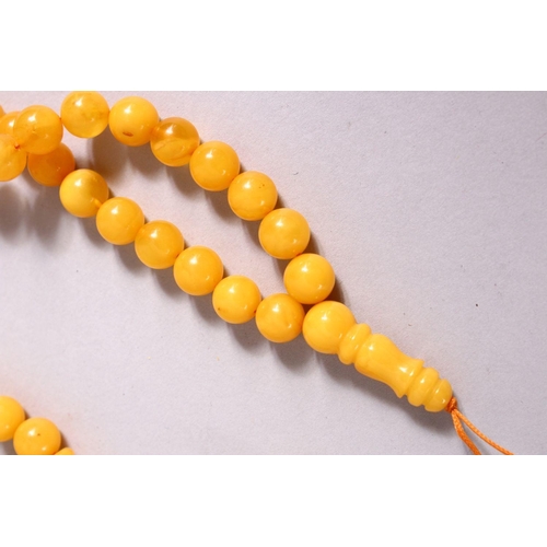 230 - A CHINESE QING DYNASTY CARVED AMBER PRAYER BEADS / ROSARY NECKLACE, comprising 66 beads, 3 spacers a... 