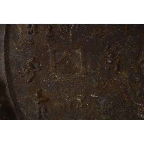 252 - A LARGE CHINESE CIRCULAR CAST BRONZE 'MIRROR' on a hardwood stand (stand AF), disc 46cm diameter.