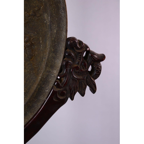 252 - A LARGE CHINESE CIRCULAR CAST BRONZE 'MIRROR' on a hardwood stand (stand AF), disc 46cm diameter.