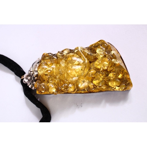 278 - A DECORATIVE PRESSED AMBER AND WHITE METAL MOUNTED NECKLACE.