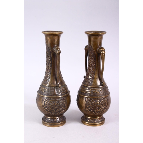 296 - A SMALL PAIR OF 20TH CENTURY CHINESE BRONZE VASES, with animal form handles and incised decoration t... 