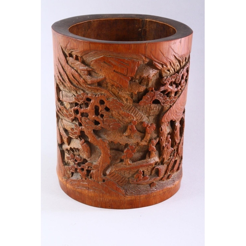 308 - A GOOD CHINESE BAMBOO BRUSH POT, deeply carved with figures in a mountainous landscape, 18cm high.