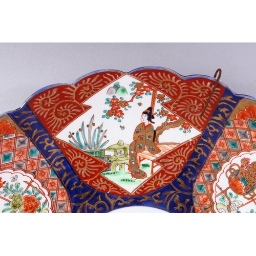 310 - A JAPANESE IMARI CHARGER, with shaped edge, painted with six panels, alternatively painted with fema... 