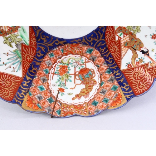 310 - A JAPANESE IMARI CHARGER, with shaped edge, painted with six panels, alternatively painted with fema... 