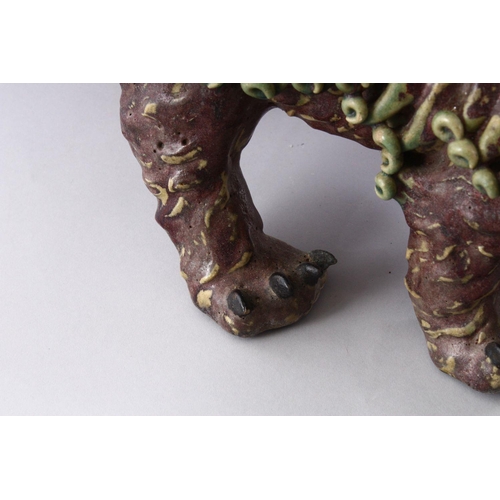 312 - A CHINESE MOULDED POTTERY LION DOG, 48cm long.