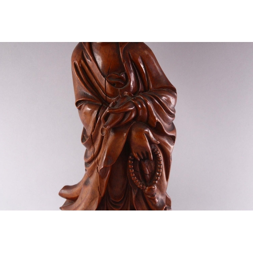 313 - A GOOD LARGE CHINESE CARVED WOOD FIGURE OF GUANYIN, standing on a dragon, 55cm high.