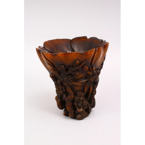 314 - A GOOD LATE 19TH CENTURY CARVED RHINO HORN LIBATION CUP, the body with prunus and blossom, 12cm high... 