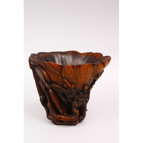 314 - A GOOD LATE 19TH CENTURY CARVED RHINO HORN LIBATION CUP, the body with prunus and blossom, 12cm high... 