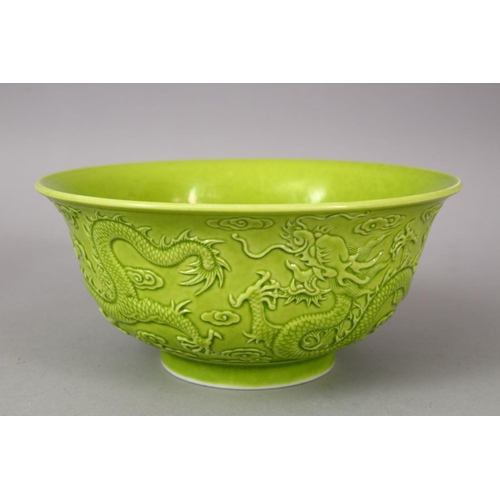 321 - A CHINESE GREEN GLAZED PORCELAIN DRAGON BOWL, with moulded decoration of dragons amongst stylized cl... 