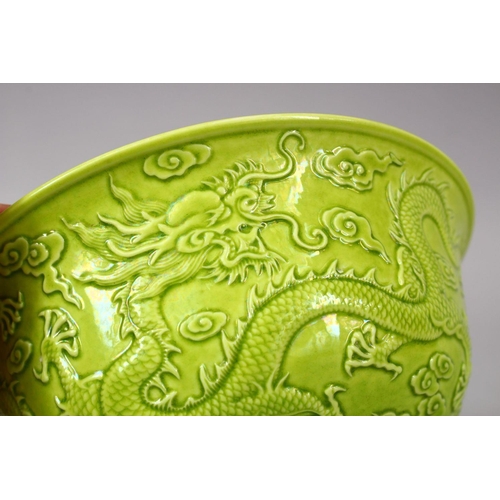 321 - A CHINESE GREEN GLAZED PORCELAIN DRAGON BOWL, with moulded decoration of dragons amongst stylized cl... 