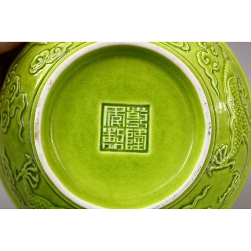 321 - A CHINESE GREEN GLAZED PORCELAIN DRAGON BOWL, with moulded decoration of dragons amongst stylized cl... 