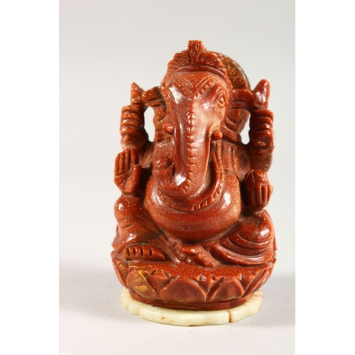 323 - A 20TH CENTURY INDIAN GOLD STONE / GLASS FIGURE OF GANESH, fixed to a carved jade / soapstone pedant... 