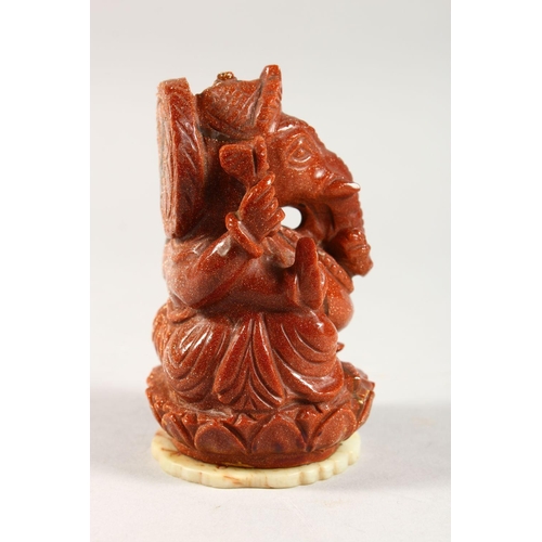 323 - A 20TH CENTURY INDIAN GOLD STONE / GLASS FIGURE OF GANESH, fixed to a carved jade / soapstone pedant... 