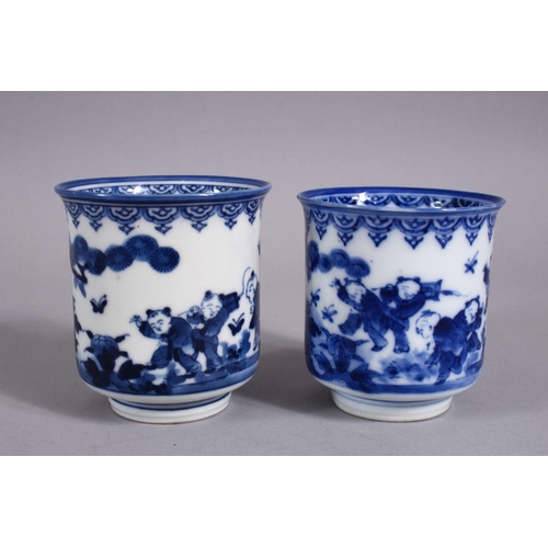 340 - A PAIR OF JAPANESE MEIJI PERIOD BLUE & WHITE PORCELAIN CUPS, each decorated with boys in landscaped ... 