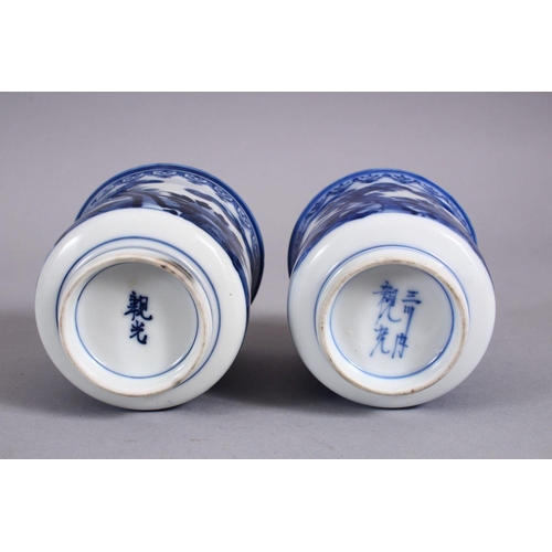 340 - A PAIR OF JAPANESE MEIJI PERIOD BLUE & WHITE PORCELAIN CUPS, each decorated with boys in landscaped ... 