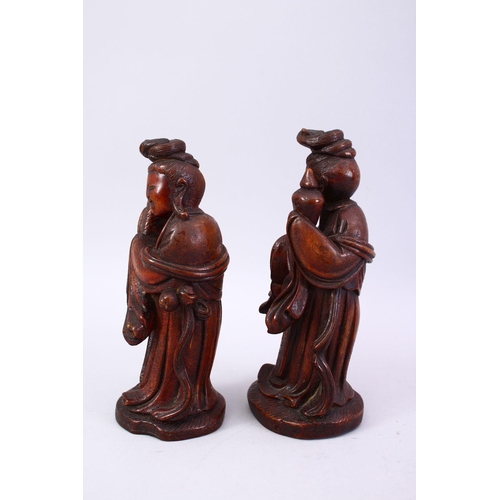 356 - A PAIR OF CHINESE 19TH CENTURY CARVED WOODEN FIGURES, 22cm high