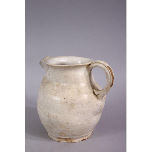 375 - AN EARLY CHINESE POTTERY JUG, with floral decoration, 11cm high.