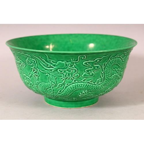 383 - A PAIR OF CHINESE GREEN GROUND MOULDED DRAGON BOWLS, 16cm diameter.