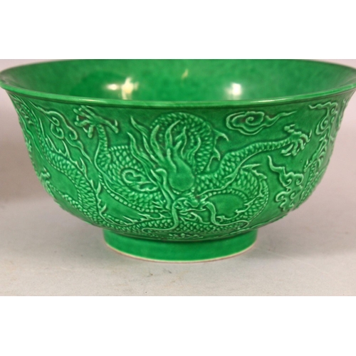 383 - A PAIR OF CHINESE GREEN GROUND MOULDED DRAGON BOWLS, 16cm diameter.