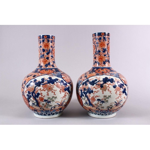 4 - A PAIR OF JAPANESE MEIJI PERIOD IMARI PORCELAIN BOTTLE VASES, decorated with panels of the three tre... 