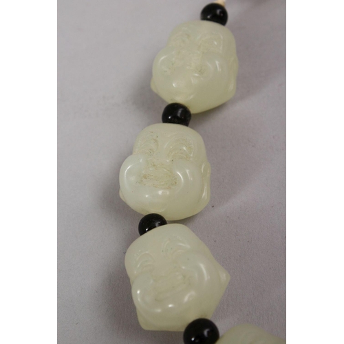 409 - A SET OF CHINESE CARVED CELADON JADE BEAD BRACELETS, the beads carved in the form of buddhas faces w... 