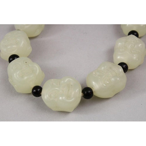 409 - A SET OF CHINESE CARVED CELADON JADE BEAD BRACELETS, the beads carved in the form of buddhas faces w... 