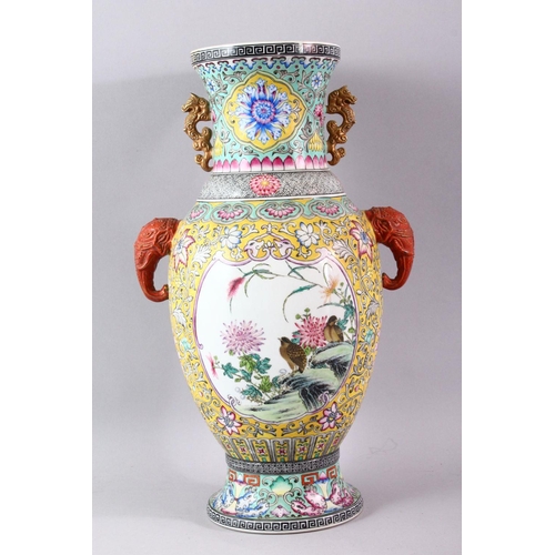 428 - A GOOD LARGE FAMILLE ROSE BALUSTER SHAPE VASE, with coral coloured elephant head handles, painted wi... 