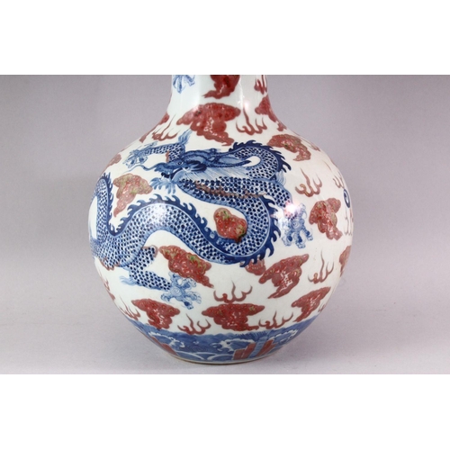 429 - A LARGE UNDERGLAZED BLUE AND COPPER RED DRAGON VASE, painted with dragons amongst clouds, six charac... 