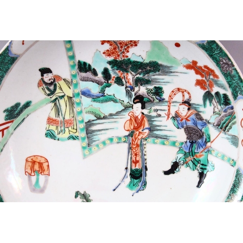 435 - A CHINESE FAMILLE VERTE CIRCULAR PORCELAIN DISH, painted with figures in a garden setting, Kangxi ma... 