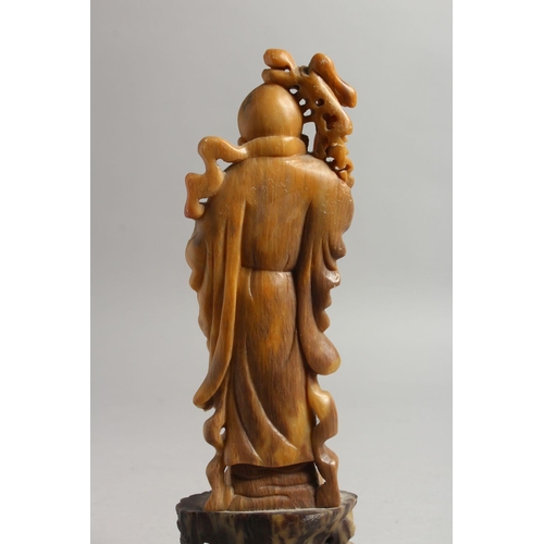 477 - A GOOD 19TH / 20TH CENTURY CHINESE CARVED SOAPSTONE FIGURE OF SHOU LAO, stood on a carved stone base... 