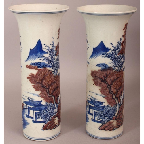 486 - A PAIR OF CHINESE COPPER-RED & UNDERGLAZE-BLUE CYLINDRICAL PORCELAIN VASES, each decorated with a ri... 