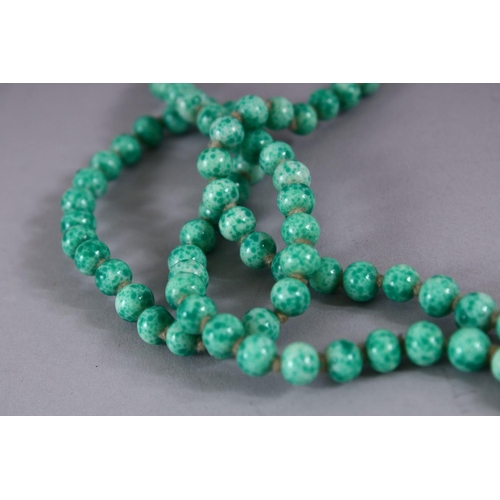 507 - A CHINESE CARVED APPLE GREEN JADE LIKE NECKLACE, 118cm approx. open.