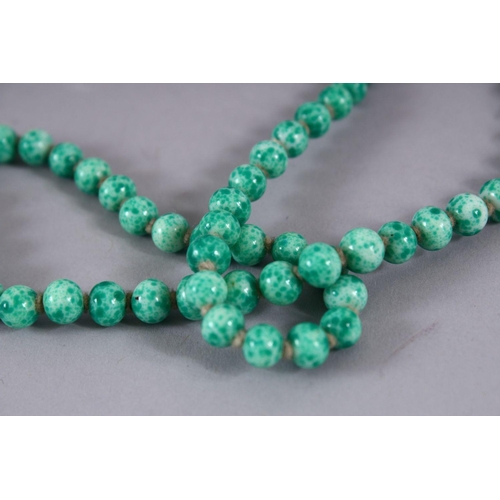 507 - A CHINESE CARVED APPLE GREEN JADE LIKE NECKLACE, 118cm approx. open.