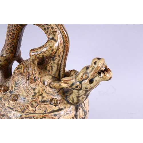 511 - AN UNUSUAL TREACLE GLAZED POTTERY WINE EWER, with dragon handle and spout, 23cm high.