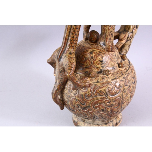 511 - AN UNUSUAL TREACLE GLAZED POTTERY WINE EWER, with dragon handle and spout, 23cm high.