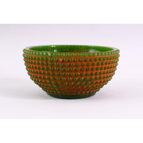 514 - A GREEN JADITE CIRCULAR BOWL with beaded decoration all over, 11.5cm diameter.