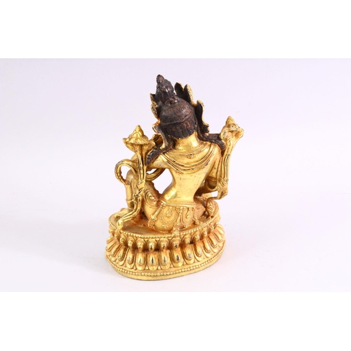 517 - A TIBETAN GILT BRONZE FIGURE OF A SEATED FEMALE DIETY, 20cm high.