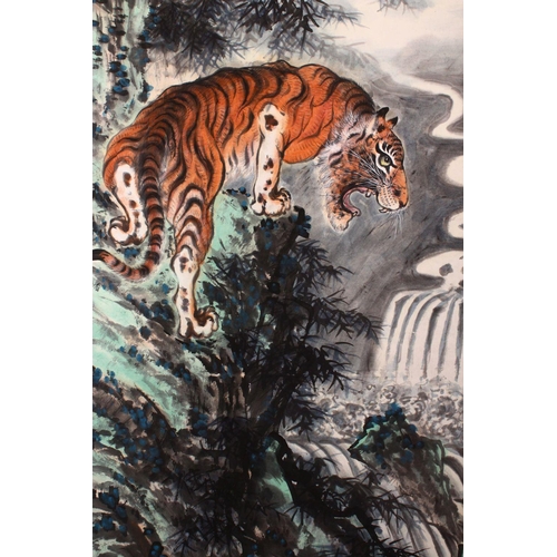 531 - A GOOD 20TH CENTURY CHINESE SCROLL PAINTING, depicting a growling tiger standing on a rocky outcrop ... 