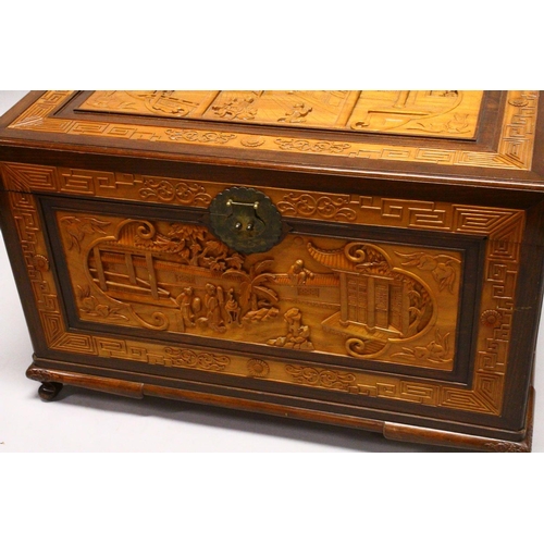 538 - A GOOD 20TH CENTURY CHINESE CARVED CAMPHORWOOD CHEST, the top and sides well carved with figures in ... 