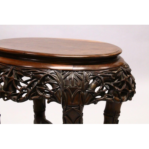 539 - A LATE 19TH CENTURY CHINESE HARDWOOD OVAL TABLE, plain top, supported on pierced and carved frieze o... 