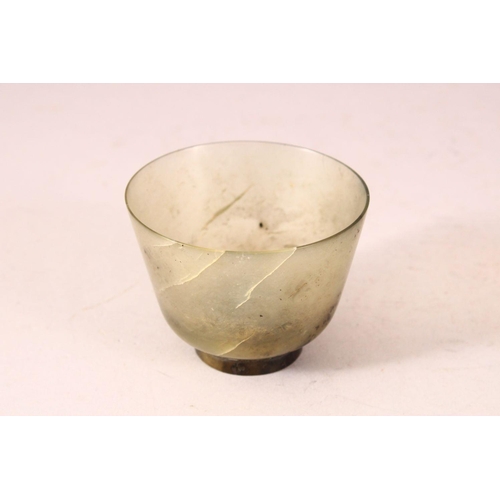 54 - A GOOD JADE CUP on a wooden stand. 2.5ins diameter.