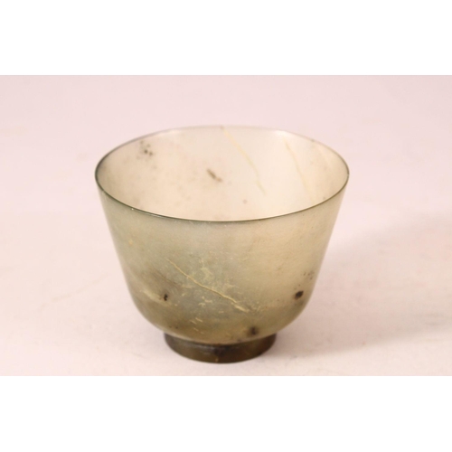 54 - A GOOD JADE CUP on a wooden stand. 2.5ins diameter.