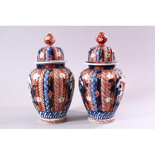 6 - A PAIR OF JAPANESE MEIJI PERIOD IMARI PORCELAIN VASES & COVERS, with panel decoration depicting disp... 